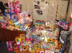 Boxed toys and stuffed animals stacked against a wall